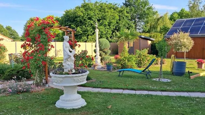Jardin fleuri avec pergola et statue