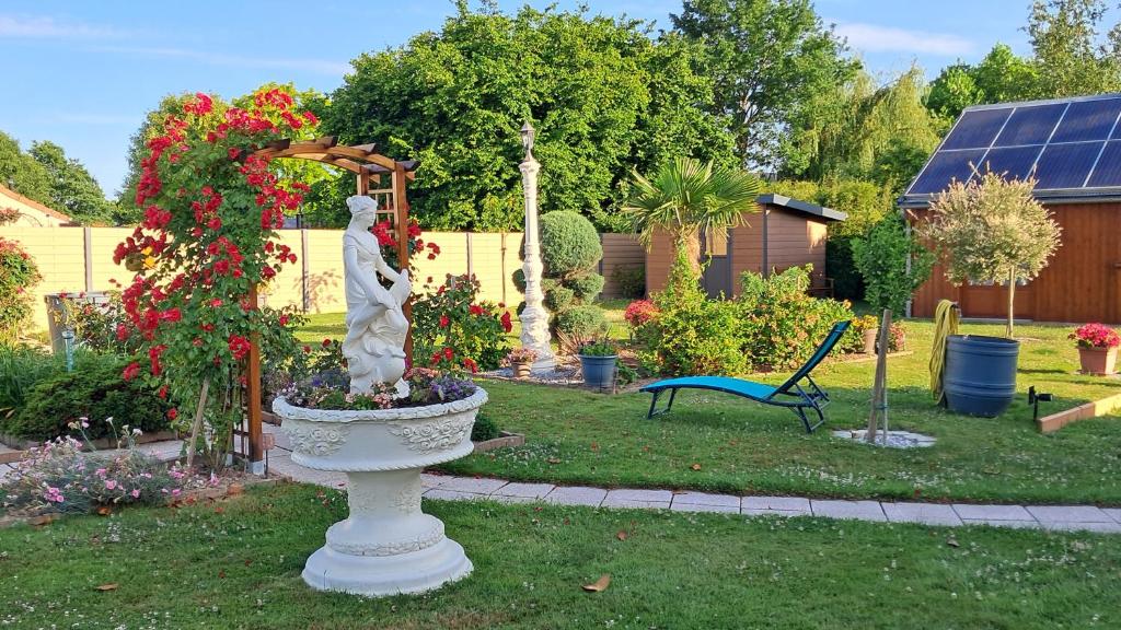 Pergola de roses et statue au jardin
